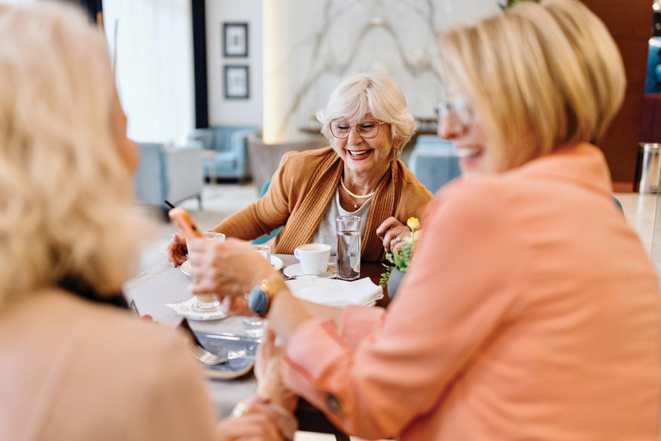 Close-up of seniors chatting and laughing around a round table