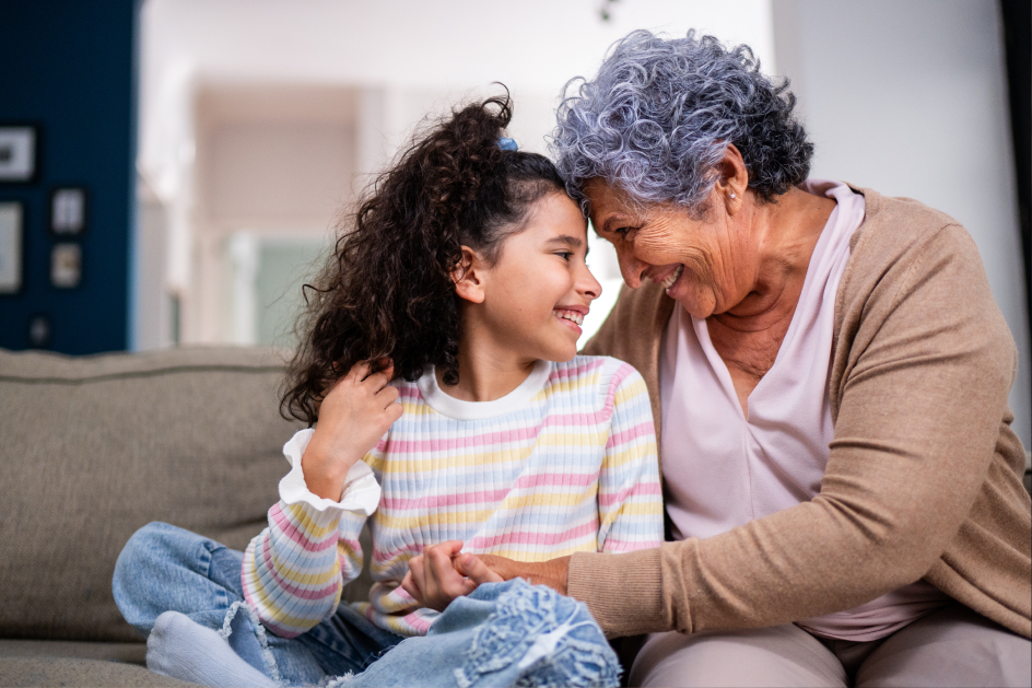 A grandmother hugs a little girl playfully.