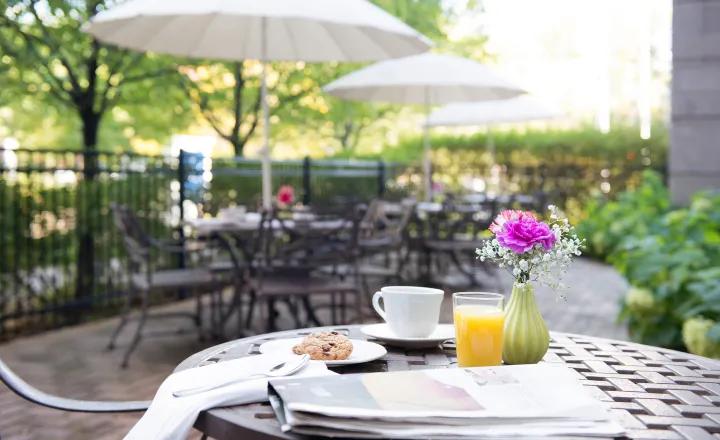 WestboroPark-home-outdoor_patio_area_with_table_in_the_foreground_with_orange_juice_and_a_newspaper_and_pastry_on_the_table