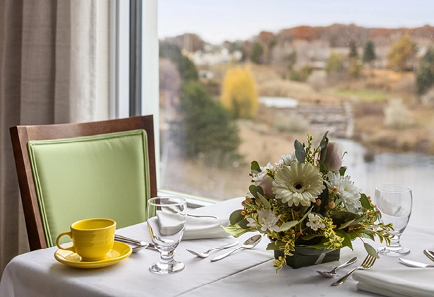Table with a window view A table set for breakfast set alongside a window.