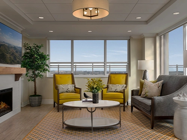 Amica Taunton's lounge, which has a fireplace and two big yellow chairs. Updated for text overlay.