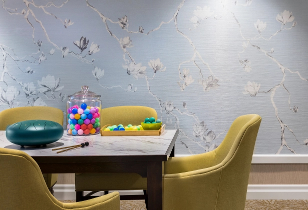 KER-MC Special Activity A memory care activity at Amica Kerrisdale set with colourful sensory balls in a glass jar, small objects on a tray, and gold chairs against a decorative wallpaper backdrop