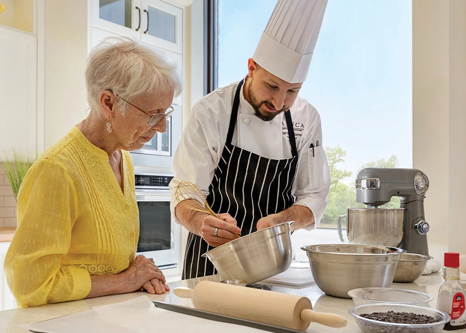 Close-up image of a chef and senior baking in a craft kitchen at Amica Pickering