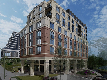 An exterior shot of Amica Credit Mills, a mid-rise two-coloured building surrounded by trees.