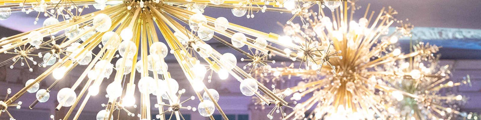 A close up of elegant, gold starburst lighting at the Conversations gala, supporting Amica Helping Hands Charity.