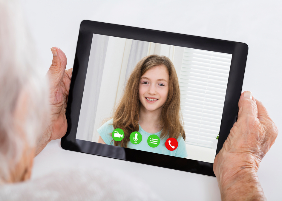 Resident using a tablet to video chat with her granddaughter