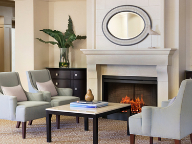 Amica Whitby senior living residence waiting area with fireplace and couches.