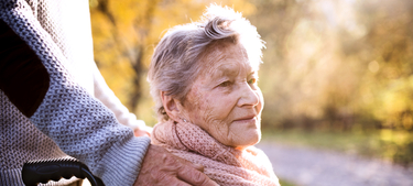 Senior man and woman in wheelchair in autumn nature.
