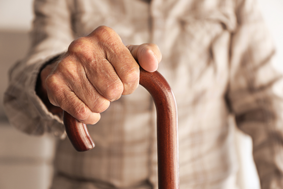 Hand of senior holding a cane, close-up