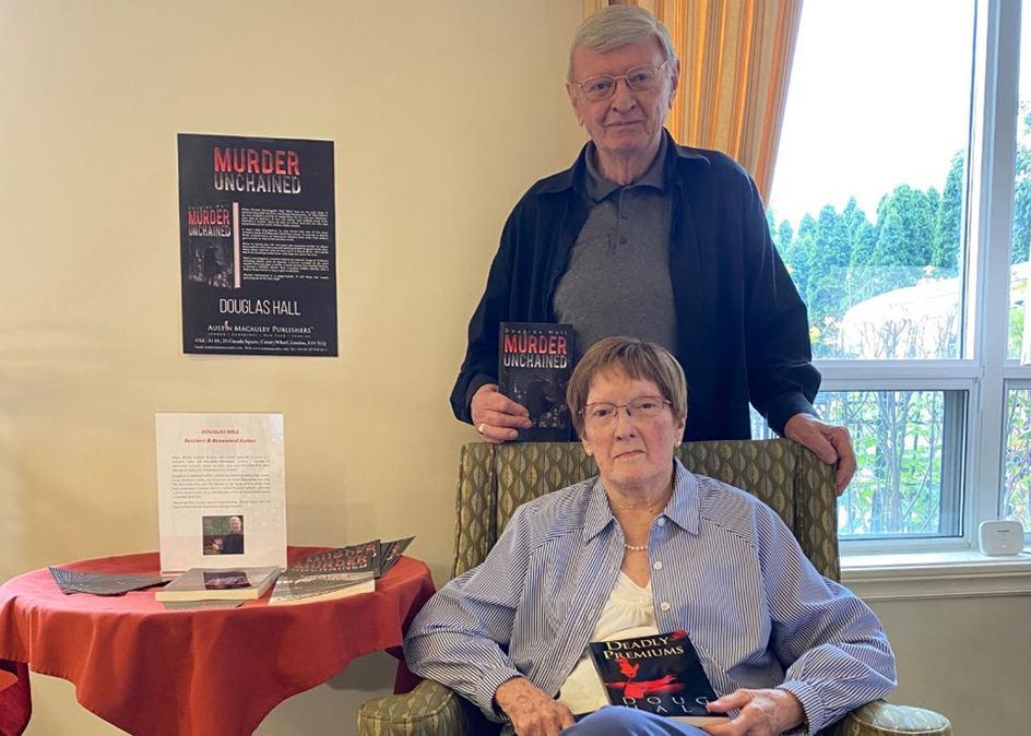 Image of Douglas Hall and his wife, Joyce Hall holding Douglas's book, 