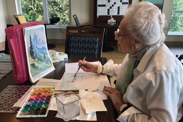 Amica resident Margaret painting with watercolours