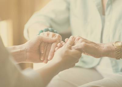 Memory care senior with team member holding hands