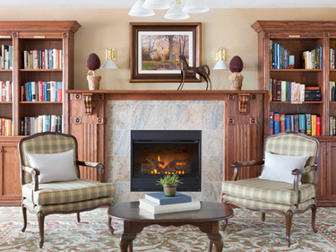 Library room with fireplace at Amica City Center senior living residence.