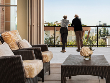 Shot of a senior couple in the balcony of Amica Lions Gate enjoying the view.
