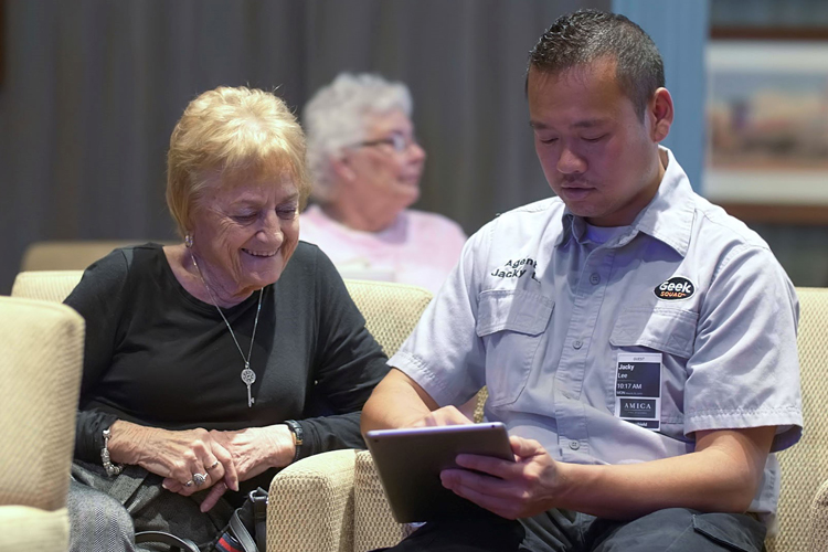 A Best Buy technician helping an Amica resident with her iPad