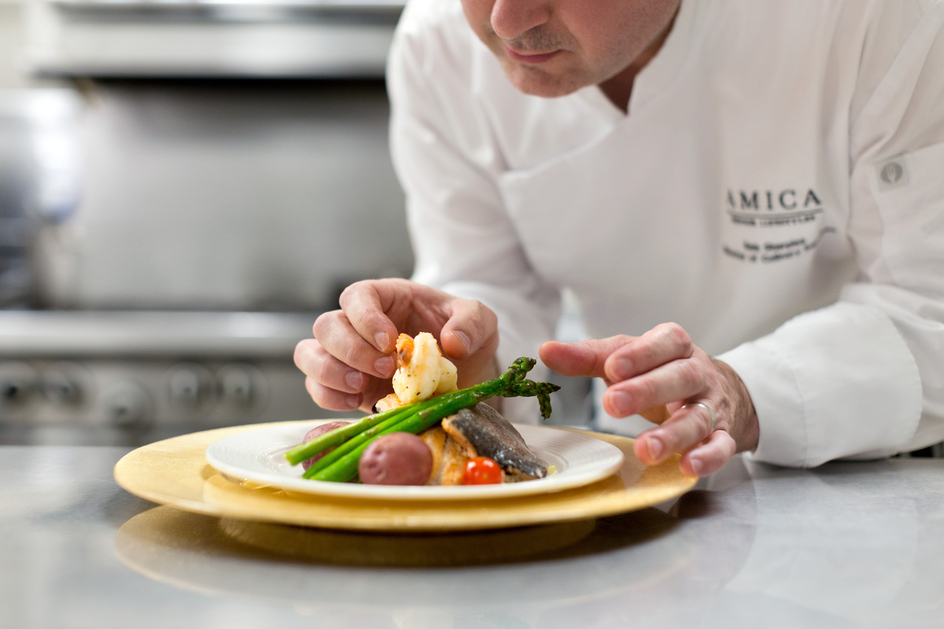 Chef putting the finishing touches to a plated meal