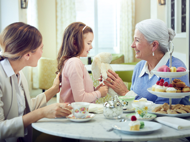 Female resident, adult daughter and granddaughter enjoying a tea party