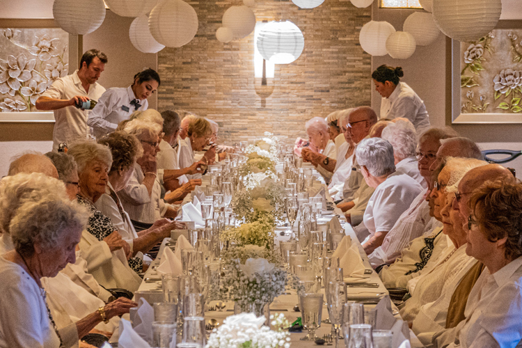 Amica residents enjoying a diner en blanc service in the dining room