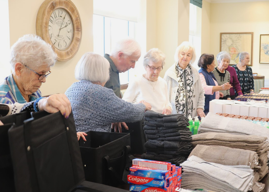 Image of a row of seniors organizing bathroom supplies.