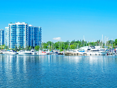 Reflections of a building and boats in the water of the Whitby Marina on Lake Ontario.