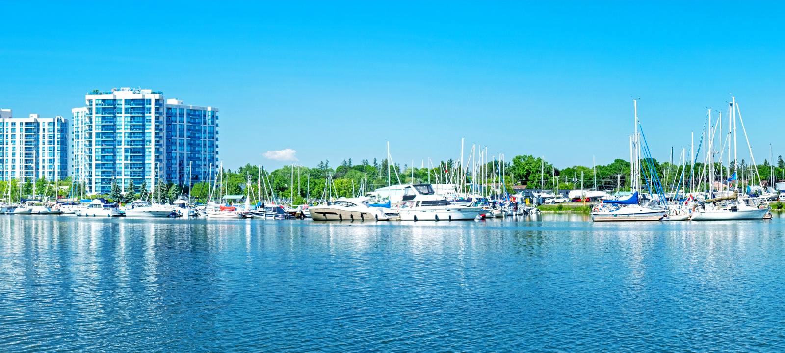 Reflections of a building and boats in the water of the Whitby Marina on Lake Ontario.