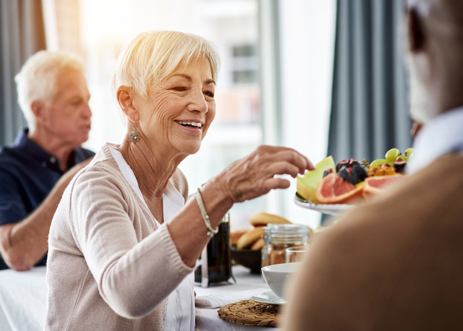 Shot of a cheerful group of senior people talking and enjoying breakfast together at home