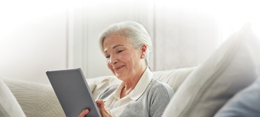 Female resident using iPad on couch