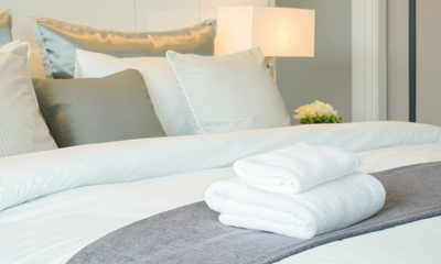 Close up of bed with folded towels at Amica senior living residence.